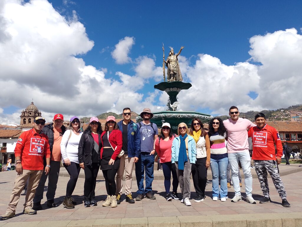 Tourists standing in front of the Inca statue in Cusco, the official meeting point for Free Walking Tour Cusco, ready to begin their tour.